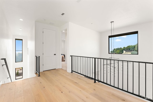 corridor with light hardwood / wood-style floors