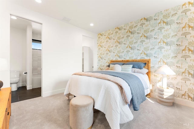 bedroom featuring ensuite bathroom and carpet flooring