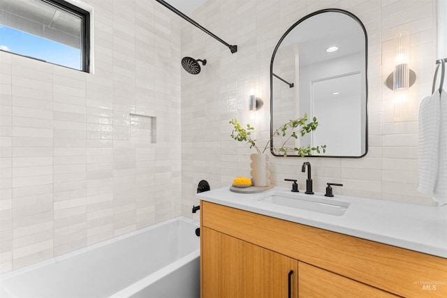 bathroom with tiled shower / bath combo and vanity