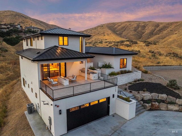 view of front facade with central AC unit, a mountain view, and a garage