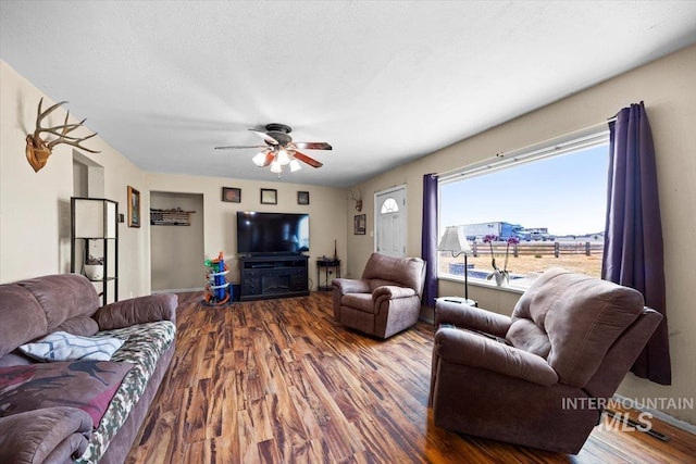 living room with hardwood / wood-style floors, a textured ceiling, and ceiling fan