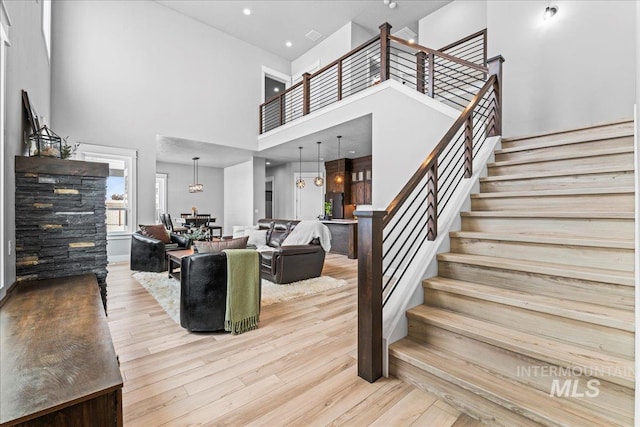 stairway with a high ceiling and wood finished floors