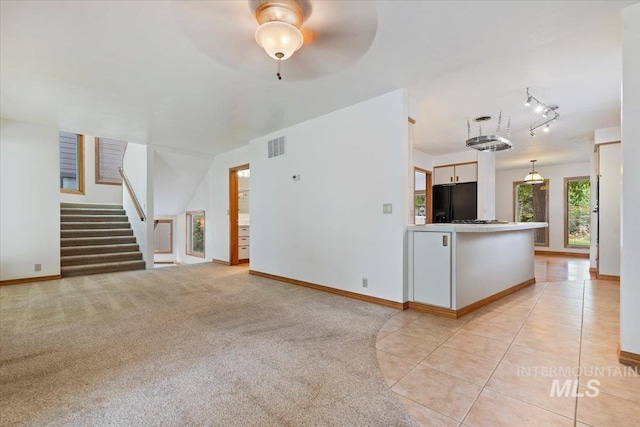 1915 N 23rd St, Boise, ID 83702 - unfurnished living room featuring ceiling fan, baseboards, stairs, light tile patterned floors, and rail lighting