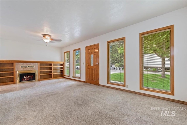 1915 N 23rd St, Boise, ID 83702 - unfurnished living room featuring light colored carpet, ceiling fan, a warm lit fireplace, and baseboards