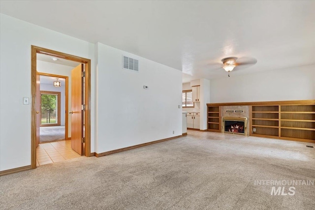 1915 N 23rd St, Boise, ID 83702 - unfurnished living room with light carpet, ceiling fan, a lit fireplace, and baseboards