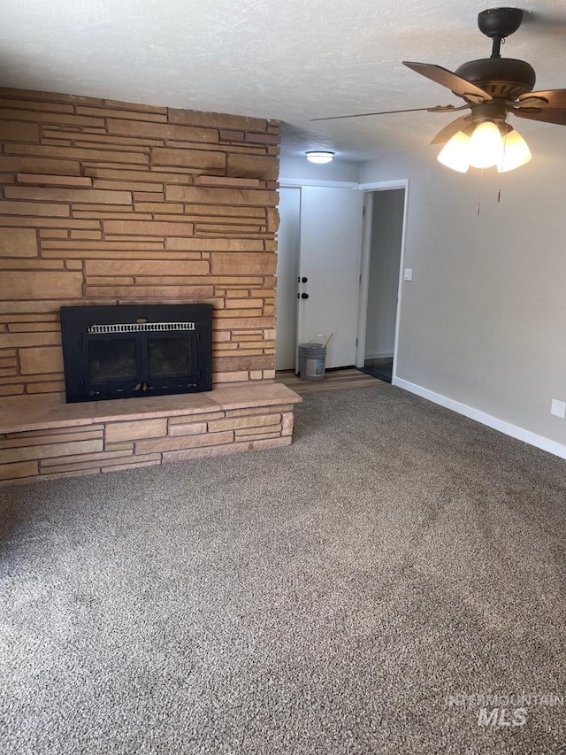 unfurnished living room featuring ceiling fan, carpet flooring, a fireplace, and a textured ceiling