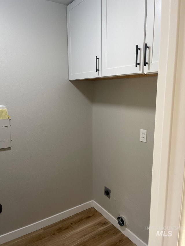 laundry room with cabinets, hookup for an electric dryer, and hardwood / wood-style floors