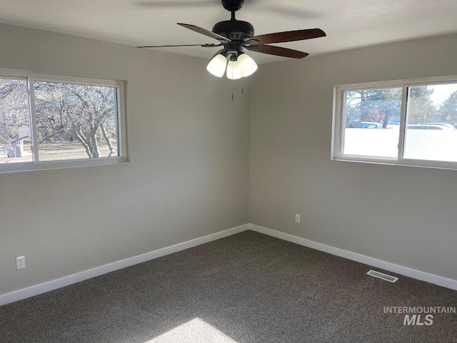 empty room featuring ceiling fan and carpet