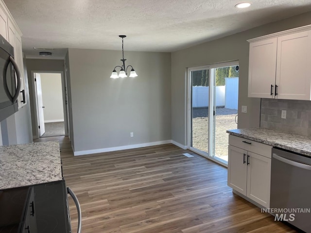 kitchen with tasteful backsplash, stainless steel dishwasher, dark wood-type flooring, and white cabinets