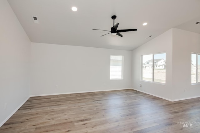 unfurnished room with ceiling fan, a healthy amount of sunlight, lofted ceiling, and light hardwood / wood-style floors