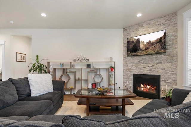 living room with light wood-type flooring and a stone fireplace