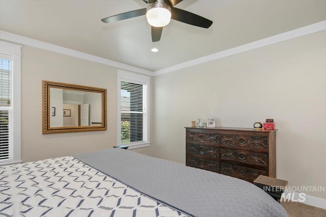 carpeted bedroom with multiple windows, ceiling fan, and crown molding