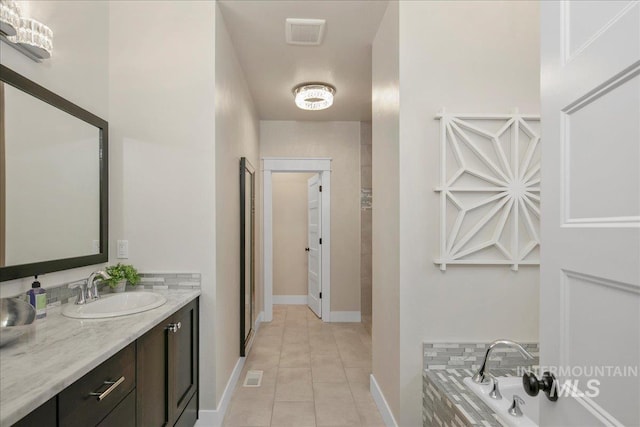 bathroom with tile patterned floors, tiled bath, and vanity