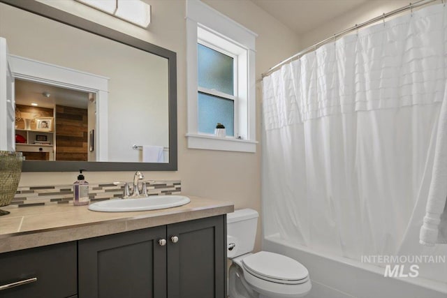 full bathroom featuring vanity, shower / bath combination with curtain, and toilet