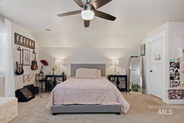 bedroom with ceiling fan, light colored carpet, and vaulted ceiling