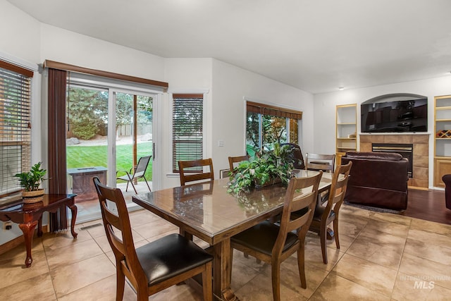 tiled dining room with a fireplace