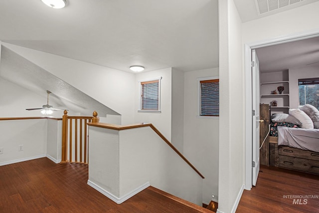 corridor featuring built in shelves and dark hardwood / wood-style flooring