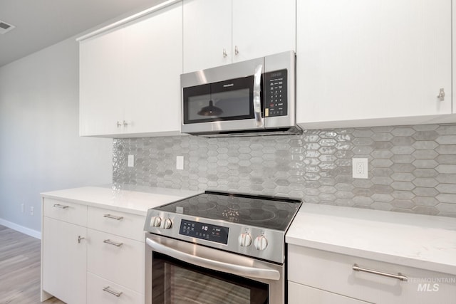 kitchen with white cabinetry, appliances with stainless steel finishes, and backsplash