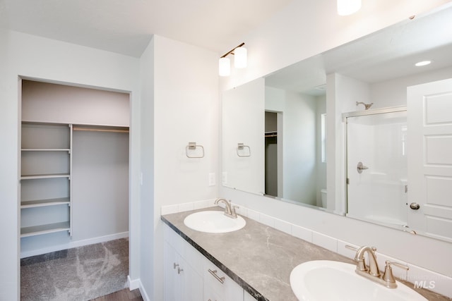 bathroom with vanity, toilet, and a shower