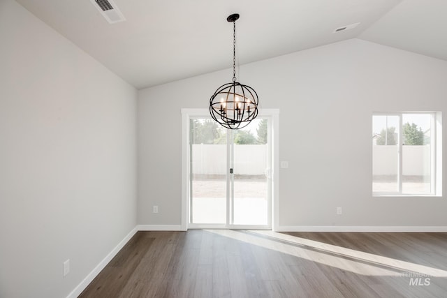 unfurnished dining area featuring lofted ceiling, a chandelier, and hardwood / wood-style floors