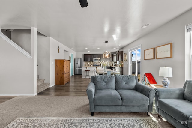 living area with visible vents, dark wood finished floors, stairway, dark carpet, and recessed lighting