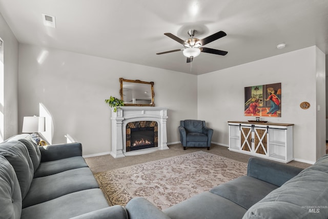 living room with carpet, visible vents, a glass covered fireplace, and baseboards