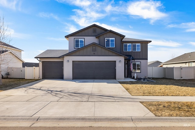 view of front of house with an attached garage, fence, concrete driveway, a gate, and board and batten siding