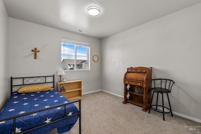 carpeted bedroom featuring baseboards and visible vents