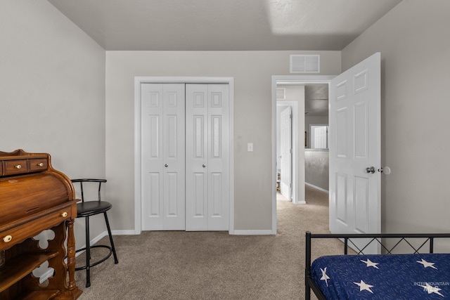 bedroom featuring a closet, light colored carpet, visible vents, and baseboards