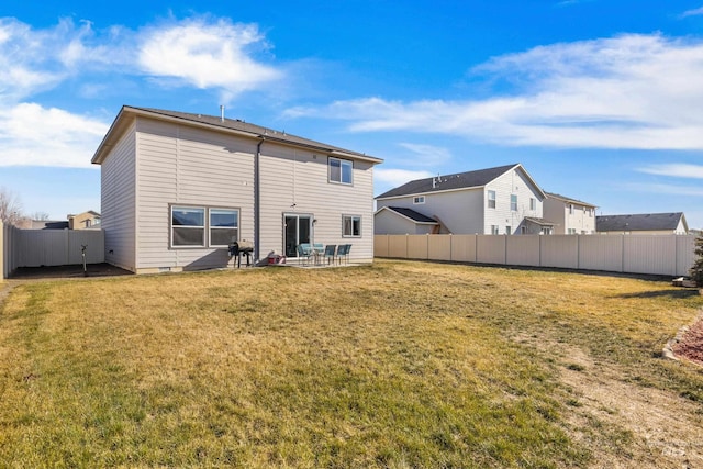 back of property with a patio area, a fenced backyard, and a lawn