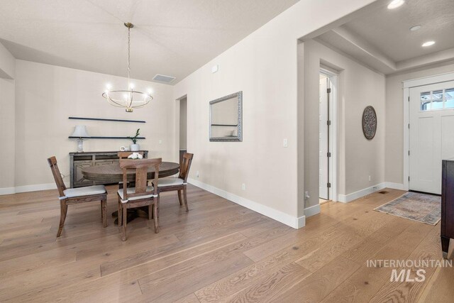 dining area featuring baseboards, a notable chandelier, and light wood-type flooring