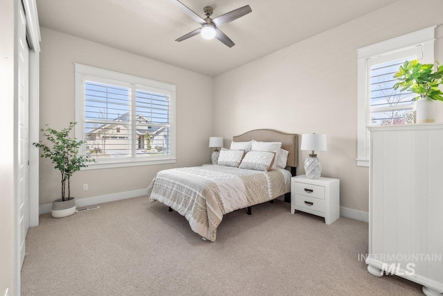 bedroom with light colored carpet, baseboards, a ceiling fan, and visible vents