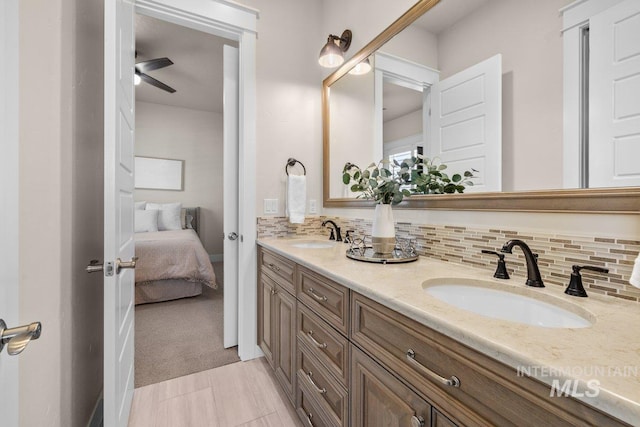 full bath with connected bathroom, a sink, double vanity, and tasteful backsplash