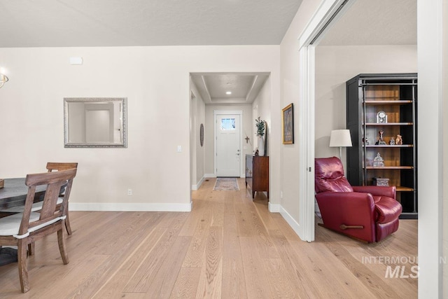 corridor featuring light wood-style floors and baseboards