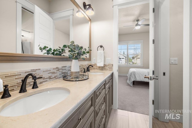 bathroom featuring backsplash, double vanity, ceiling fan, and a sink