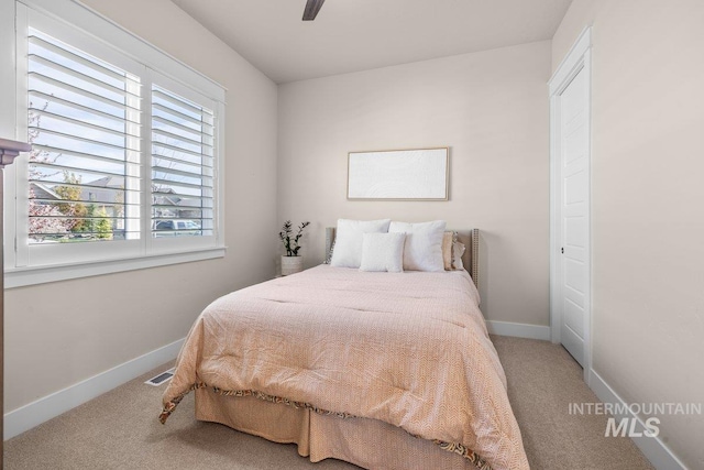 bedroom with carpet floors, visible vents, a ceiling fan, and baseboards