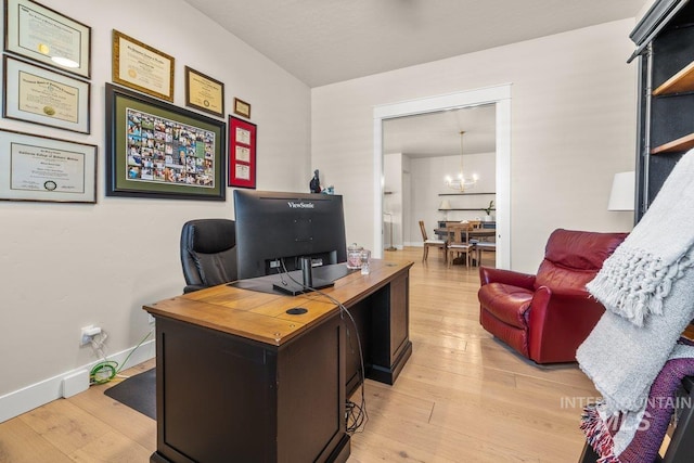 office featuring a chandelier, light wood-style flooring, and baseboards