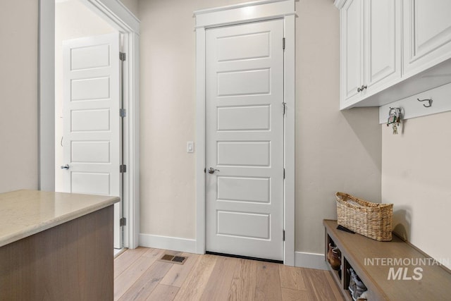 mudroom featuring visible vents, light wood finished floors, and baseboards