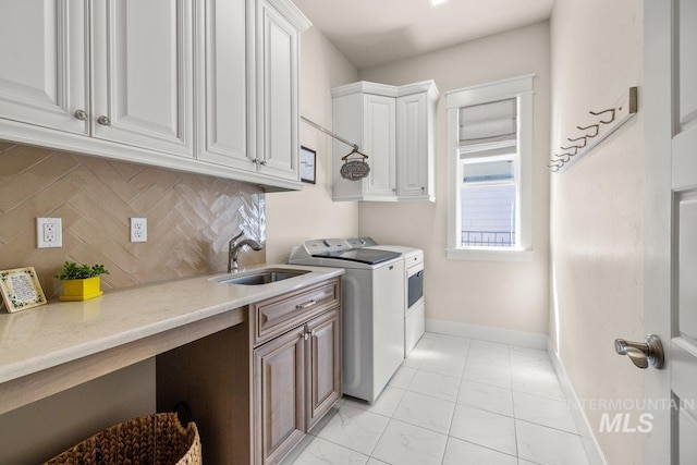 laundry room featuring a sink, marble finish floor, cabinet space, baseboards, and independent washer and dryer
