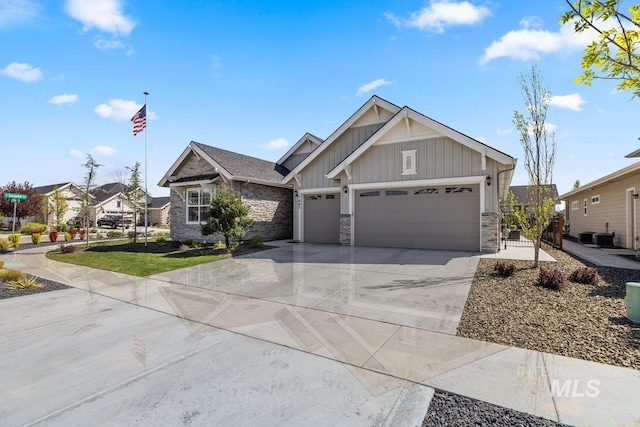 view of front facade with driveway, stone siding, board and batten siding, an attached garage, and a residential view