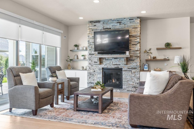 living area with a fireplace, wood finished floors, and recessed lighting