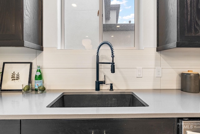 interior details featuring dark brown cabinets, sink, and tasteful backsplash