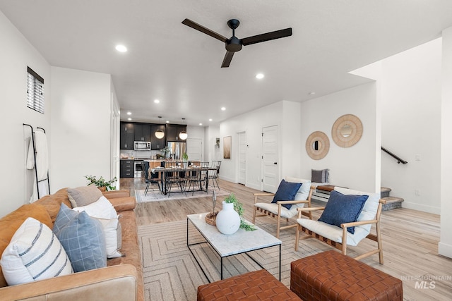 living room featuring ceiling fan and light hardwood / wood-style flooring