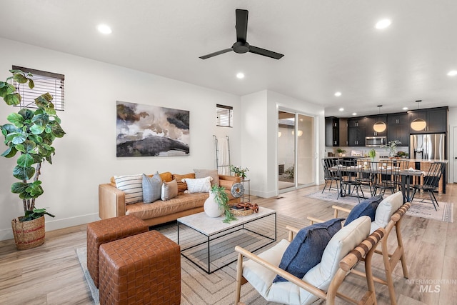 living room with ceiling fan and light hardwood / wood-style flooring