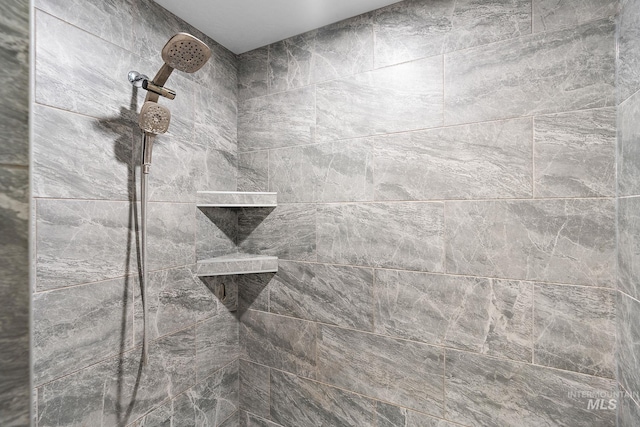 interior details featuring tiled shower