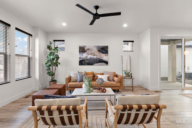 living room with ceiling fan and light hardwood / wood-style flooring