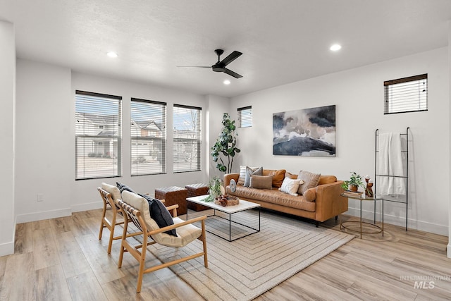 living room featuring light hardwood / wood-style flooring and ceiling fan