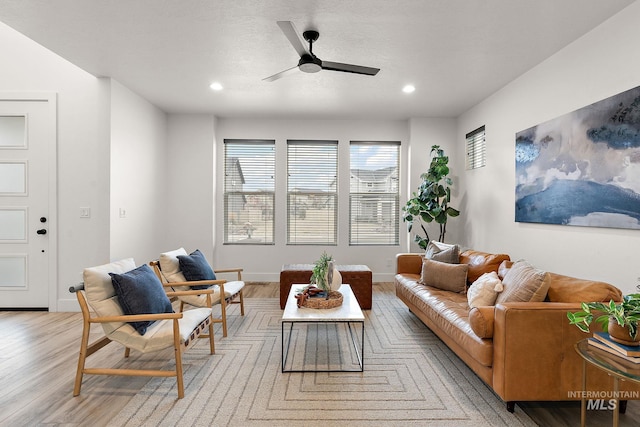 living room featuring ceiling fan and light hardwood / wood-style floors