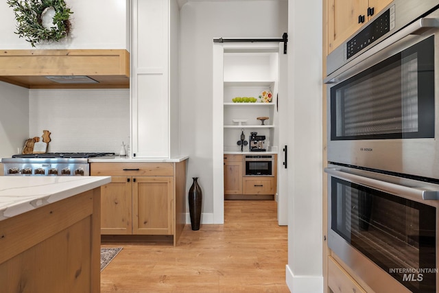 6635 Big Wood Way, Star, ID 83669 - kitchen with light wood-style flooring, stainless steel double oven, tasteful backsplash, and baseboards