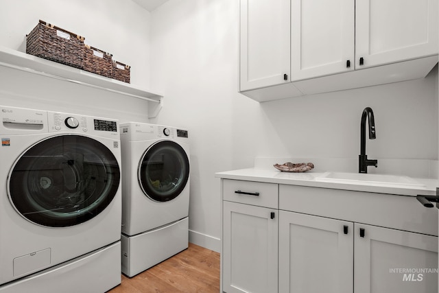 6635 Big Wood Way, Star, ID 83669 - laundry area with cabinet space, washer and clothes dryer, light wood finished floors, and baseboards